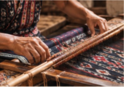 Pengrajin menenun kain tenun dengan alat tenun tradisional